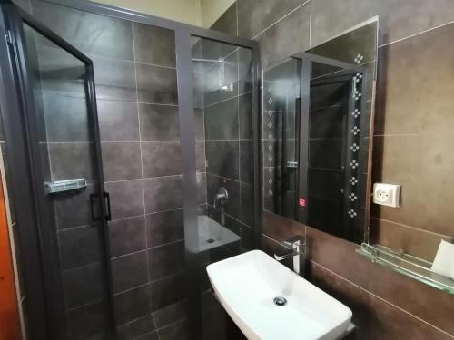 a bathroom with a sink and a shower and a mirror at Le Choisy Mauritius in Mont Choisy