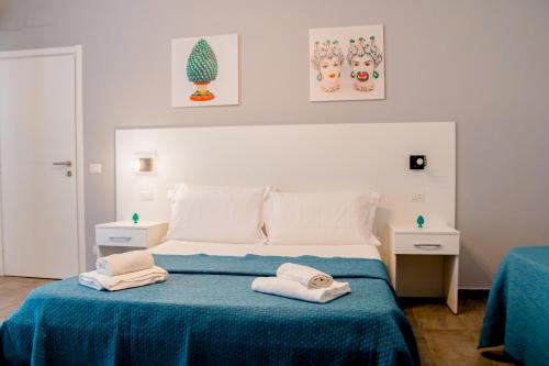 1 dormitorio con 1 cama con 2 toallas en La Querencia, en Palermo