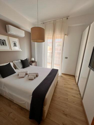 a large white bed in a room with a large window at Casa Vitale in Aci Castello