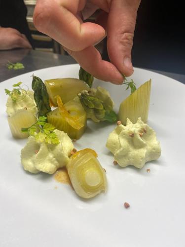 a person picking up a piece of food on a plate at Hotel de la Plage Santa Vittoria in Algajola