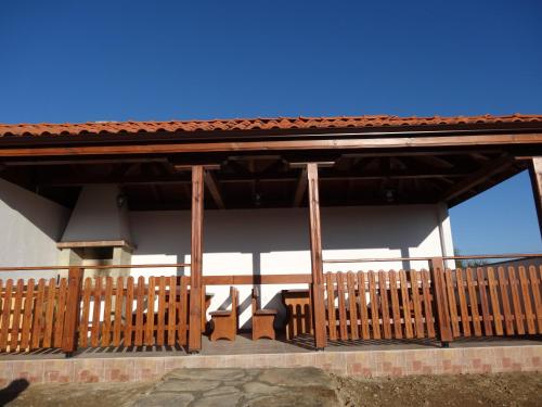 a porch of a building with a wooden fence at Guest House Ivanini Houses in Tryavna