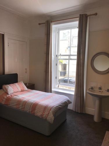 a bedroom with a bed and a window and a sink at Roselodge Guest House in Aberdeen