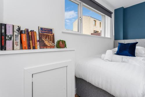a bedroom with a white bed and a shelf with books at Cheerful Stays - Livingston - 4 Bedroom 3 Bath home in Livingston