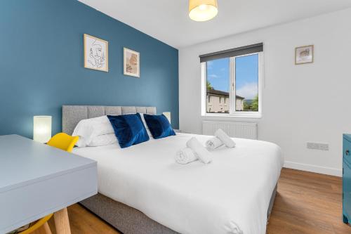 two beds in a bedroom with blue walls and a window at Cheerful Stays - Livingston - 4 Bedroom 3 Bath home in Livingston