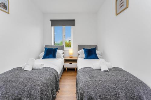 two beds in a room with blue pillows at Cheerful Stays - Livingston - 4 Bedroom 3 Bath home in Livingston