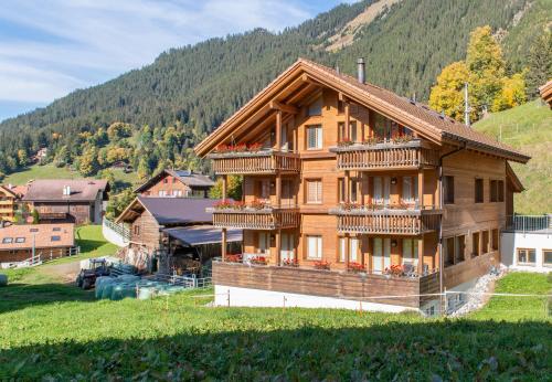 a large wooden house with balconies on a hill at Chalet Stella Duplex Penthouse in Wengen