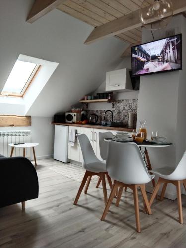 a kitchen and dining room with a table and chairs at Apartamenty Równia 2 in Ustrzyki Dolne