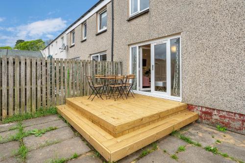 a wooden deck with a table and chairs on it at Cheerful Stays - Livingston - 4 Bedroom 3 Bath home in Livingston