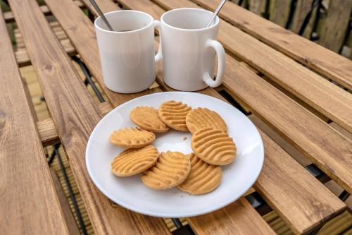 a plate of cookies on a table with two mugs at Cheerful Stays - Livingston - 4 Bedroom 3 Bath home in Livingston