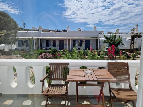 un tavolo e sedie su un balcone con una casa di Anais a Mykonos Città