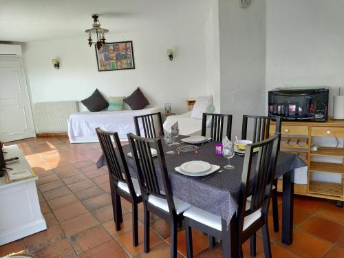 - une salle à manger avec une table, des chaises et un lit dans l'établissement Rez-de-villa Mougins, à Mougins