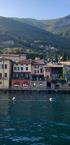 a group of buildings next to a body of water at Hotel Garnì Bartabel in Gargnano