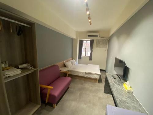 a living room with a purple couch and a tv at 近 距離 in Taichung