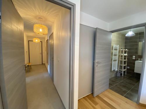 a hallway with a door leading to a bathroom at L'ORANGERAIE - Garage, Balcon, Vélos, Proche Lac, Vue Montagne in Annecy