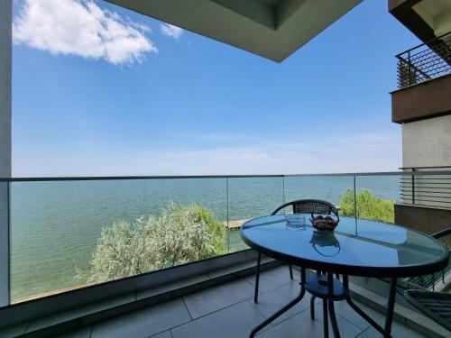a table on a balcony with a view of the ocean at RoApart Mamaia - Riva Lake Apartments in Mamaia