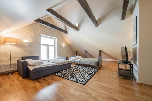 - une chambre mansardée avec 2 lits et une télévision dans l'établissement Old Town - Muurivahe Apartment, à Tallinn