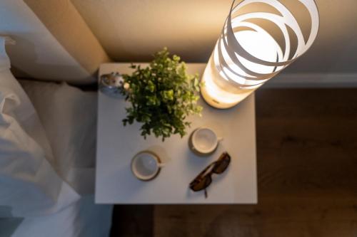 a table with a vase and a plant and a lamp at Casa Bardi in San Gimignano