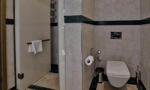 a bathroom with a white toilet and a shower at Dreamland Golf Hotel Baku in Baku