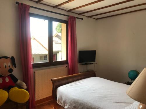 - une chambre avec un lit et une fenêtre avec un ours en peluche dans l'établissement Maison familiale proche dune Pyla, plages, lac de Cazaux, sites de loisirs, à La Teste-de-Buch