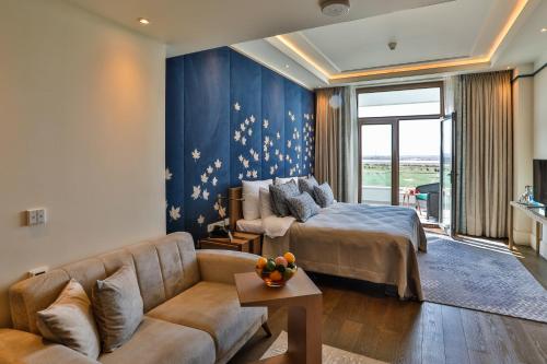 a hotel room with a bed and a couch at Dreamland Golf Hotel Baku in Baku