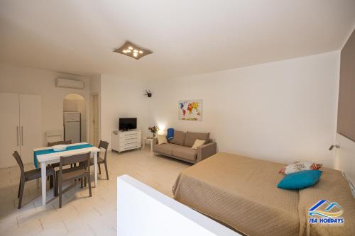 a bedroom with a bed and a table and a couch at Residence VILLA FIORITA in Roccella Ionica