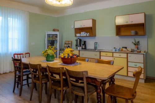 a kitchen with a wooden table with chairs and a dining room at Grüner Baum Wachau - Retro Frühstückspension in Mautern