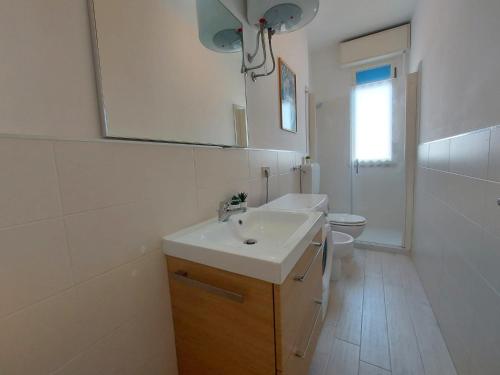 Baño blanco con lavabo y aseo en Montebianco 30 en Lido di Pomposa