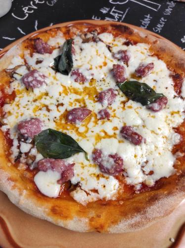 a pizza with cheese and basil on a plate at Podere Casanova in Montespertoli