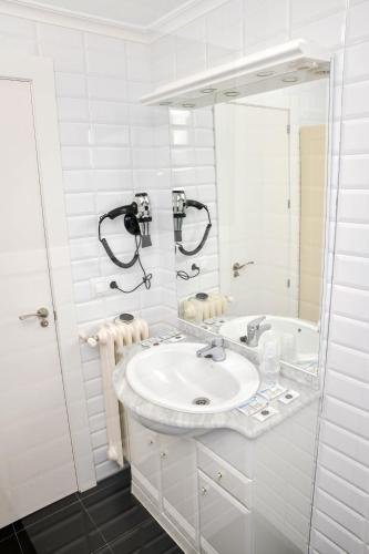 a white bathroom with a sink and a tub at Villa Conce in La Bañeza