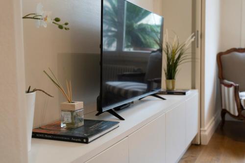 a living room with a television on a white cabinet at Casa Bardi in San Gimignano