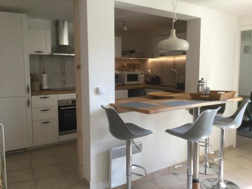 a kitchen with a counter and stools in it at Spacious Pied à Terre with courtyard garden in Dernacueillette