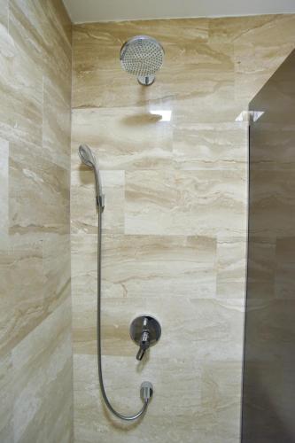 a shower with a shower head in a bathroom at Apartments Menuet in Budva