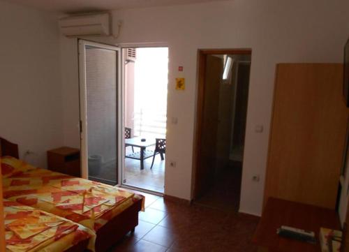a bedroom with a bed and a sliding glass door at Kuća Todorović in Budva