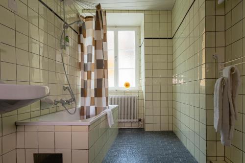 baño con bañera, lavabo y ventana en Grüner Baum Wachau - Retro Frühstückspension, en Mautern