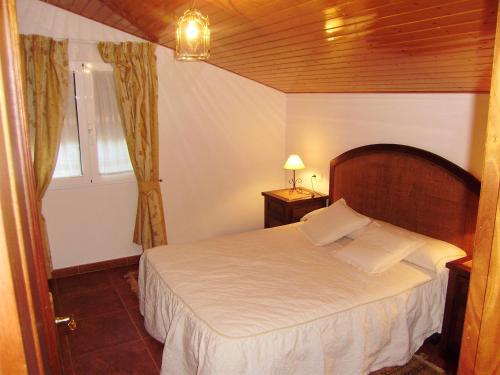 Schlafzimmer mit einem Bett und einem Fenster in der Unterkunft 3 bedrooms house with enclosed garden and wifi at O Savinao 3 km away from the beach in Licín