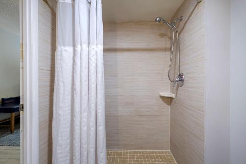 e bagno con doccia con tenda bianca. di Comfort Inn & Suites Alexandria West a Alexandria