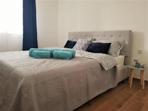 a bedroom with a large bed with blue and white pillows at Apartman Astra in Sremska Mitrovica