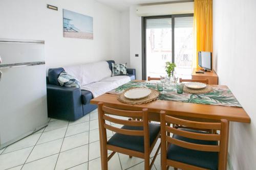 a kitchen and living room with a table and a couch at Residence Villa Dei Pini in Rimini