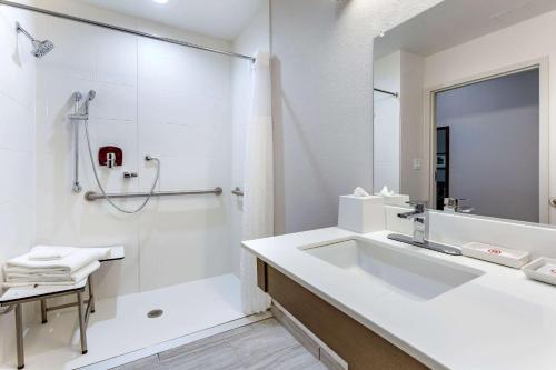 La salle de bains blanche est pourvue d'un lavabo et d'une douche. dans l'établissement Comfort Suites Scottsdale Talking Stick Entertainment District, à Scottsdale