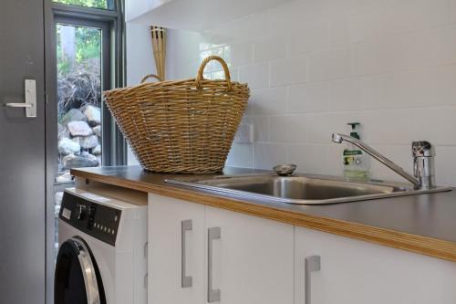 a kitchen with a sink and a washing machine at Cordova - Perfect Summer or Winter Getaway in Merimbula