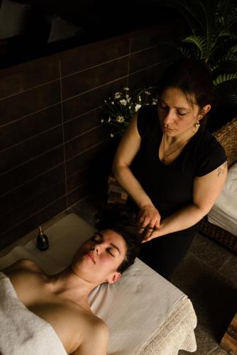 a woman is giving a man a bath in a bath tub at I Tre Poggi Dimora di Charme in Canelli