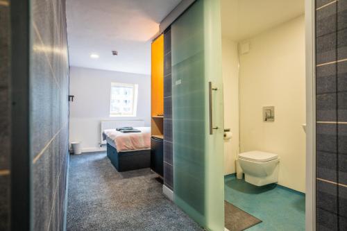 a bathroom with a toilet and a bed in a room at Apartment Chinatown 301 in Newcastle upon Tyne