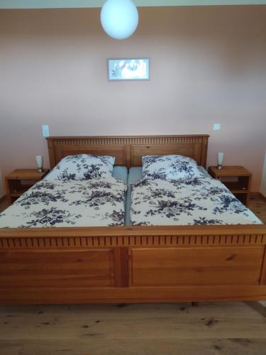 a bedroom with a wooden bed with two pillows at Ferienwohnung Maintalblick in Mainleus