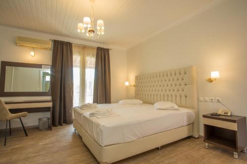 a bedroom with a large white bed and a desk at BEL AIR HOTEL in Nydri