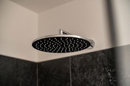 a shower with a shower head in a bathroom at Pension Grafenau in Schenna