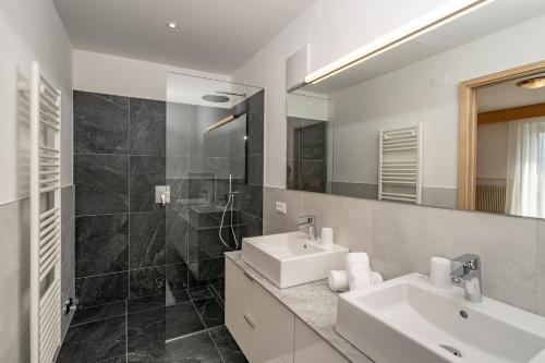 a bathroom with two sinks and a mirror at Pension Grafenau in Schenna