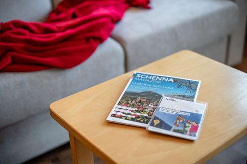 a coffee table with two books on top of it at Pension Grafenau in Schenna