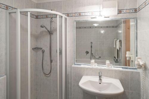 a bathroom with a shower and a sink and a shower at Pension Grafenau in Schenna