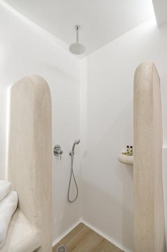 a white bathroom with a shower and a sink at Villa Adriana Hotel in Agios Prokopios