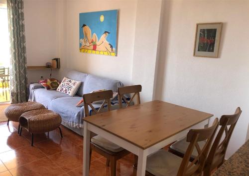 蓋博德帕洛斯的住宿－Cala Reona Holiday Apartment，客厅配有桌子和沙发
